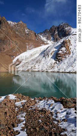 A mountain lake with emerald water is like mirror A mountain lake with emerald water is like mirror 98270483
