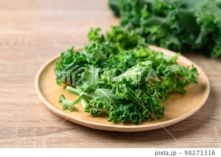 Sliced Green Kale or leaf cabbage on wooden plate, Healthy vegetable Sliced Green Kale or leaf cabbage on wooden plate, Healthy vegetable 98271316