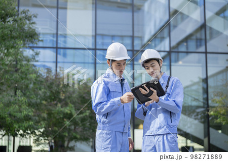 タブレットの画面を見ながら話す作業服姿の2人の男性 　施工管理　イメージ　　 98271889