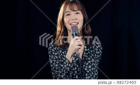 スポットライトを浴びて歌う女性 ライブ コンサート カラオケ スポットライトを浴びて歌う女性 ライブ コンサート カラオケ 98272405