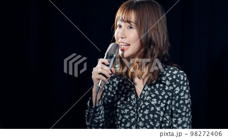 スポットライトを浴びて歌う女性 ライブ コンサート カラオケ スポットライトを浴びて歌う女性 ライブ コンサート カラオケ 98272406