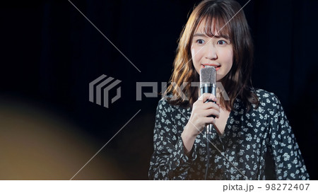 スポットライトを浴びて歌う女性　ライブ　コンサート　カラオケ 98272407