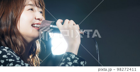 スポットライトを浴びて歌う女性　ライブ　コンサート　カラオケ 98272411