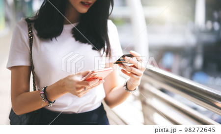 Woman consumer using creadit card and smartphone shopping via online application for cashless. Woman consumer using creadit card and smartphone shopping via online application for cashless. 98272645