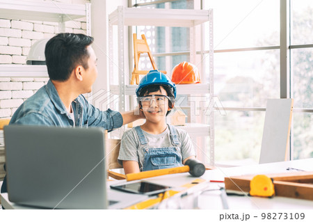 Southeast asian family father and son talking together at home workshop office 98273109