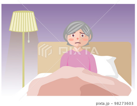 夜、ベッドの中で眠れずにボーッとしている高齢女性 98273603