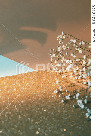 Floral composition. Natural layout. Spring decoration. White flowers golden bokeh glitter beige color block paper composition empty space background. Floral composition. Natural layout. Spring decoration. White flowers golden bokeh glitter beige color block paper composition empty space background. 98273950