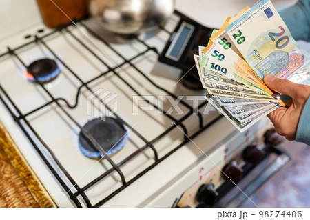 The family calculates gas and utility bills. Euro and dollar bills in hands. The concept of increasing the cost of natural gas supply and payment. Energy crisis. High cost, the price of gas. 98274406