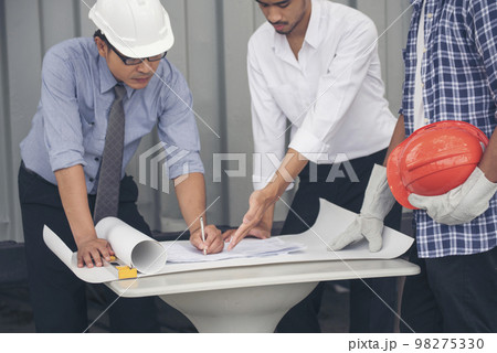 Civil Construction engineer teams shaking hands together wear work helmets worker on construction site. Foreman industry project working engineer teamwork. Two asian engineer team shake hands together 98275330