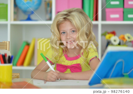 little girl studying at home at the table 98276140