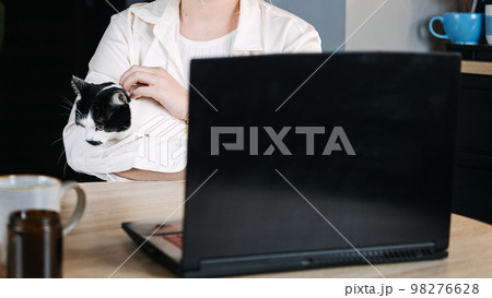 Veterinary Telemedicine Services, Online veterinarian services for virtual pet care. Young woman with cat and using laptop for video call meeting and telemedicine with veterinary from home 98276628