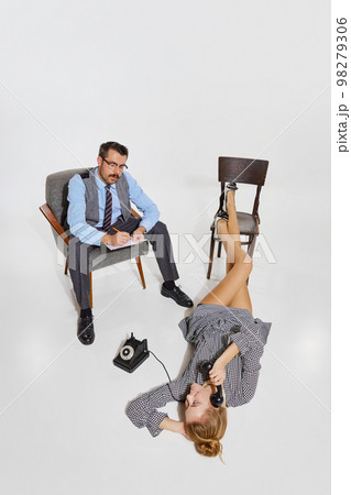 Extraordinary communication. Businessman and woman, personal assistance over grey background. Concept of business, employment, work Extraordinary communication. Businessman and woman, personal assistance over grey background. Concept of business, employment, work 98279306