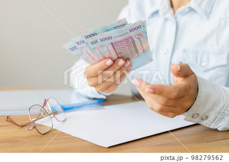 Woman holding Ukrainian 1000 bill banknotes. Helping hand. Woman holding Ukrainian 1000 bill banknotes. Helping hand. 98279562