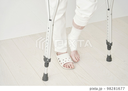 骨折して松葉杖で歩く女性　顔無し 98281677