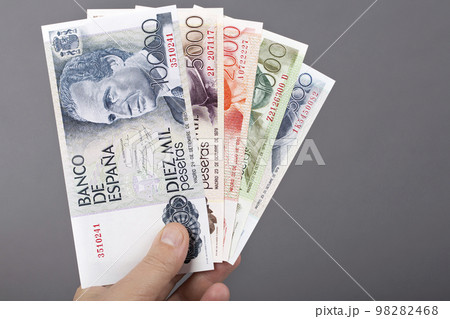 Spanish money in the hand on a gray background Spanish money in the hand on a gray background 98282468