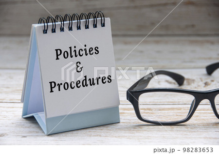 Policies and procedures text on notepad with glasses on white wooden cover background. Policies and procedures text on notepad with glasses on white wooden cover background. 98283653