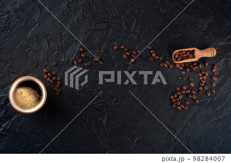 Coffee cup and beans, overhead flat lay shot on a black slate background Coffee cup and beans, overhead flat lay shot on a black slate background 98284007