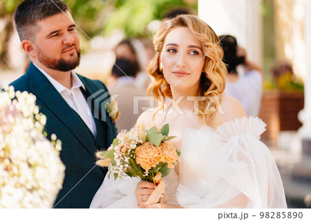 the groom looks in love at the beautiful and happy bride the groom looks in love at the beautiful and happy bride 98285890