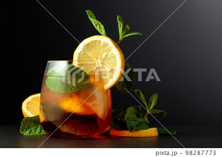 Cold refreshing summer cocktail Cuba libre with lemon slices and mint. Cold refreshing summer cocktail Cuba libre with lemon slices and mint. 98287773