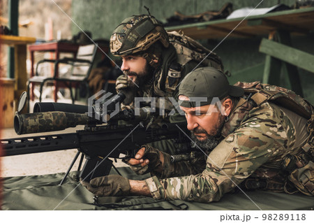 Soldier in camouflage preparing the rifle for shooting Soldier in camouflage preparing the rifle for shooting 98289118