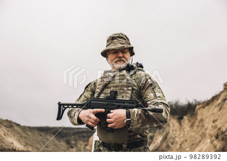 Mature soldier with a rifle in hands on a shooting range 98289392