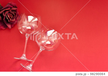Empty wine glasses lies on a red background. Valentines day concept. Empty wine glasses lies on a red background. Valentines day concept. 98290064