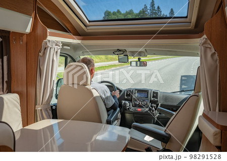 Man driving on a road in the Camper Van RV 98291528