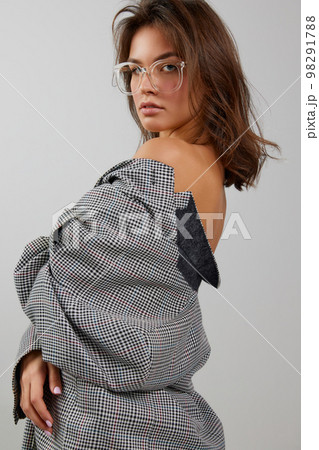 Portrait of young beautiful girl wearing stylish oversize jacket isolated over white background. Concept of beauty, fashion, human emotions Portrait of young beautiful girl wearing stylish oversize jacket isolated over white background. Concept of beauty, fashion, human emotions 98291788