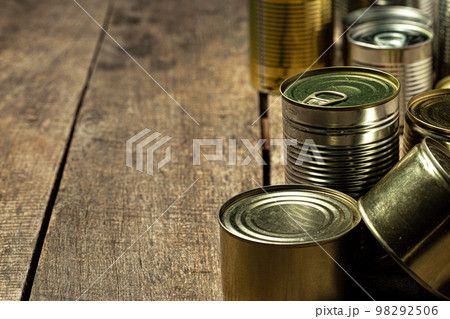 Tin cans with food on the table. 98292506