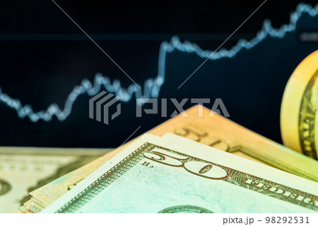 Dollars in front of a monitor with a price chart. Forex and trading. Dollars in front of a monitor with a price chart. Forex and trading. 98292531
