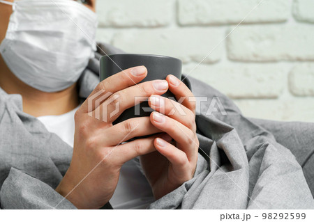 Caucasian man staying at home during Coronavirus quarantine wearing medical mask 98292599