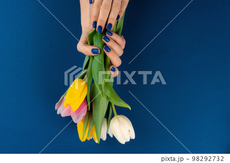 Woman hands with manicure holding colorful tulips 98292732