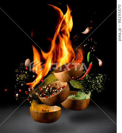 Hot Spices and seasonings powder splash, explosion on black background with flame Hot Spices and seasonings powder splash, explosion on black background with flame 98293870