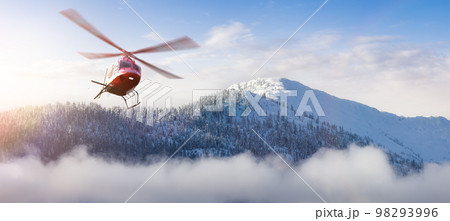 Helicopter flying over the Rocky Mountains during a colorful sunset. 98293996