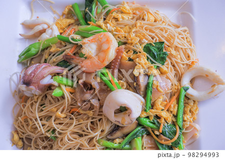 Hong Kong recipe stir-fried noodles with egg, fresh squid, shrimp, pickled squid and Hong Kong vegetables. Hong Kong recipe stir-fried noodles with egg, fresh squid, shrimp, pickled squid and Hong Kong vegetables. 98294993