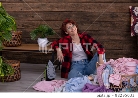 A young woman in a good mood before starting to iron clothes. 98295033