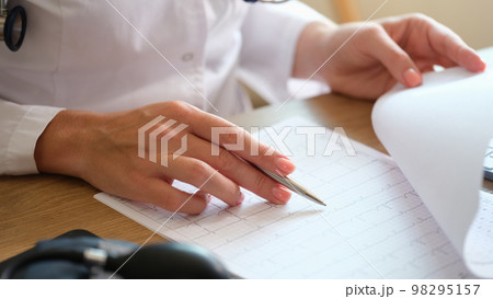 Doctor at table in office examines results of the patient's medical tests. 98295157