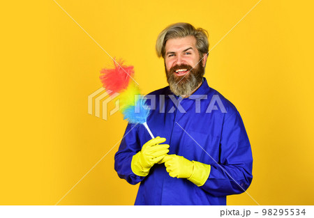 cleaning and home concept. Male Sweeping with small duster broom. cleaning service. housekeeping business. Cleaning the apartment. man use duster. hipster holding the cleaning tool. Unfair situation 98295534
