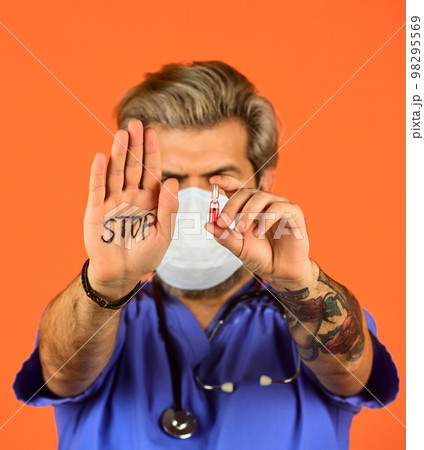 Open palm stop gesture. Stop epidemic. Virus concept. Danger zone. Epidemic infection. Critical number or density of susceptible hosts. Epidemic threshold. Man in medical lab. Protective mask Open palm stop gesture. Stop epidemic. Virus concept. Danger zone. Epidemic infection. Critical number or density of susceptible hosts. Epidemic threshold. Man in medical lab. Protective mask 98295569