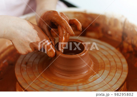Potter creates a pitcher on a pottery wheel Potter creates a pitcher on a pottery wheel 98295802