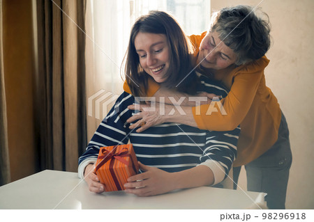 Grandmother make a gift to her grand daughter. Grandmother make a gift to her grand daughter. 98296918