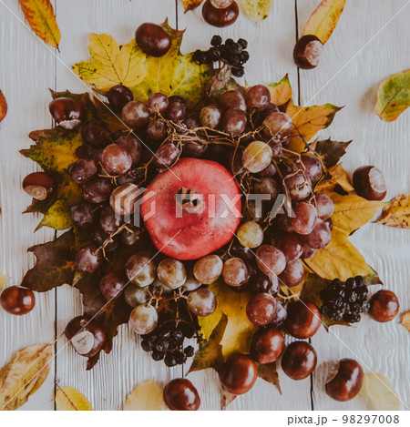 Autumn still life. apple, pumpkin, pomegranate, viburnum, leaves. Flatlay background Autumn still life. apple, pumpkin, pomegranate, viburnum, leaves. Flatlay background 98297008