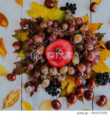 Autumn still life. apple, pumpkin, pomegranate, viburnum, leaves. Flatlay background Autumn still life. apple, pumpkin, pomegranate, viburnum, leaves. Flatlay background 98297009
