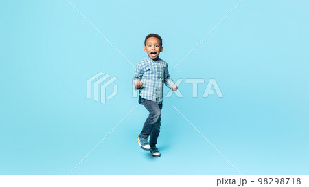 Yes. Happy little black kid boy shaking fists, making winner gesture, celebrating victory, blue background, panorama Yes. Happy little black kid boy shaking fists, making winner gesture, celebrating victory, blue background, panorama 98298718
