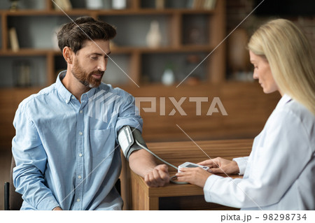 Hypertension. Female Doctor Measuring Arterial Blood Pressure Of Male Patient In Clinic 98298734