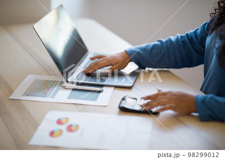 Cropped of woman using computer and calculator 98299012