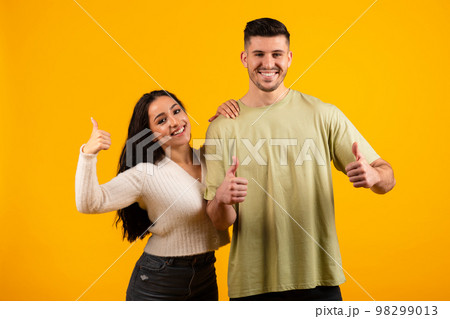 Smiling millennial arabic female and male show thumbs up approve and advise ad and offer 98299013