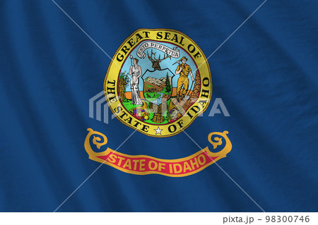 Idaho US state flag with big folds waving close up under the studio light indoors. The official symbols and colors in banner Idaho US state flag with big folds waving close up under the studio light indoors. The official symbols and colors in banner 98300746
