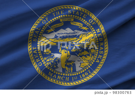 Nebraska US state flag with big folds waving close up under the studio light indoors. The official symbols and colors in banner 98300763