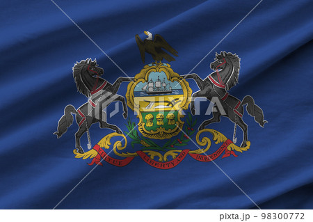 Pennsylvania US state flag with big folds waving close up under the studio light indoors. The official symbols and colors in banner Pennsylvania US state flag with big folds waving close up under the studio light indoors. The official symbols and colors in banner 98300772